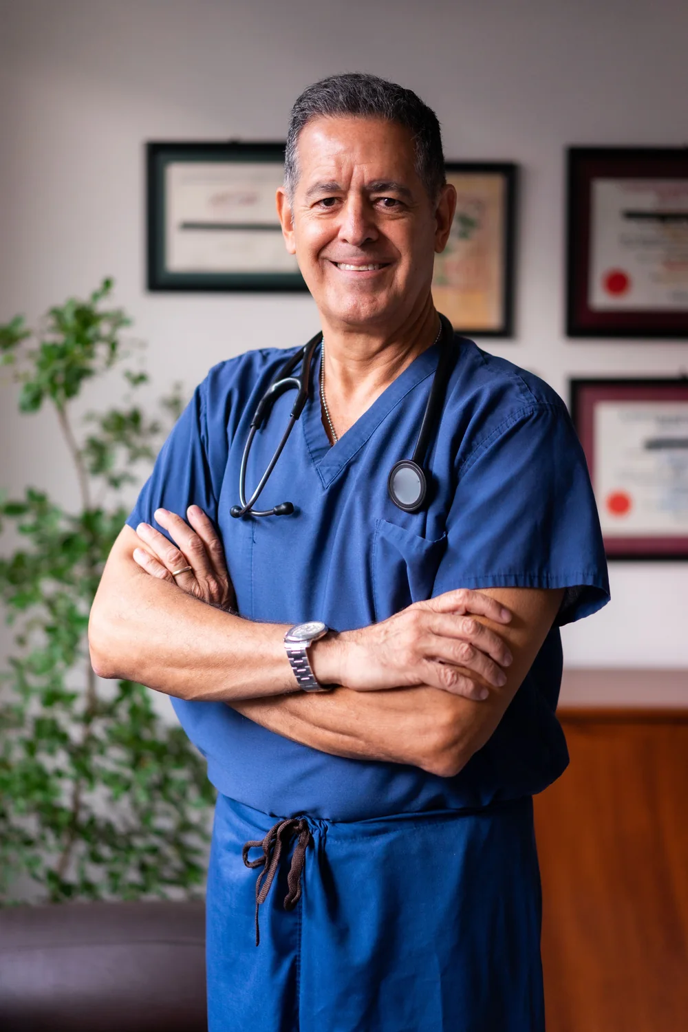 Illustrative photo of a smiling male clinician in blue scrubs
