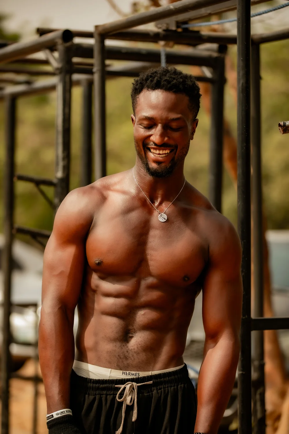 Smiling muscular man at an outdoor gym